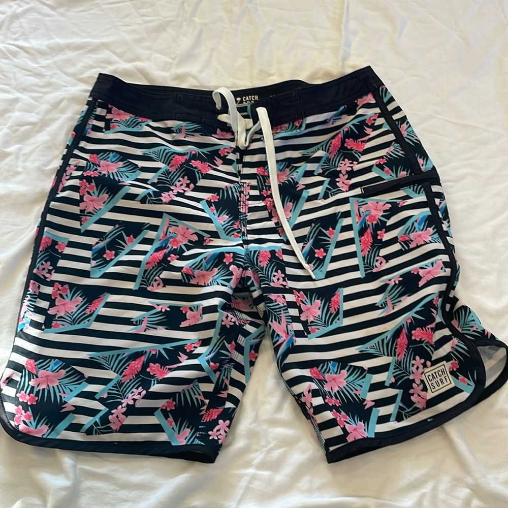 Catch surf board shorts. Cool striped pattern with bright pink flowers.